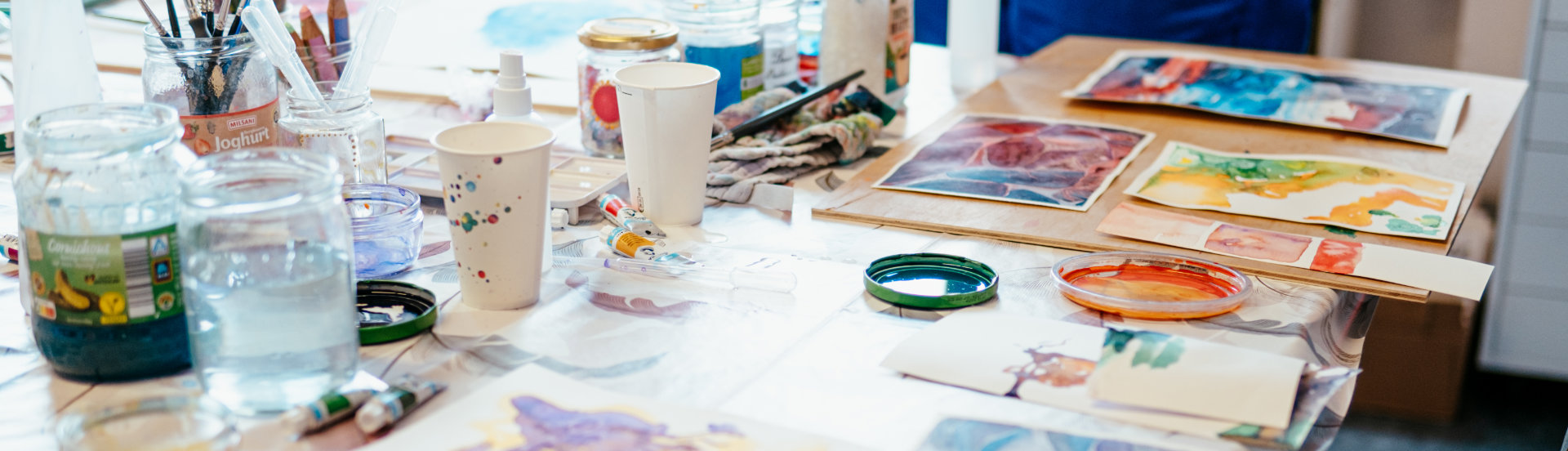 Ein Tisch mit verschiedenen Aquarell-Bildern der Kursteilnehmerinnen.