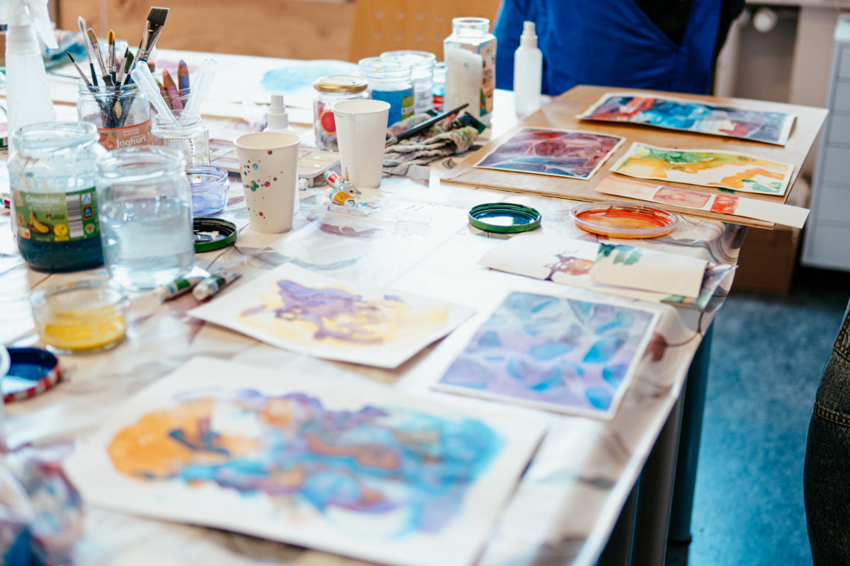 Ein Tisch mit verschiedenen Aquarell-Bildern der Kursteilnehmerinnen.